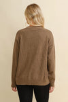 Woman wearing a brown sweater with a white horseshoe design on a beige background - equestrian fashion outfitters