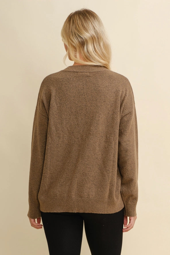 Woman wearing a brown sweater with a white horseshoe design on a beige background - equestrian fashion outfitters