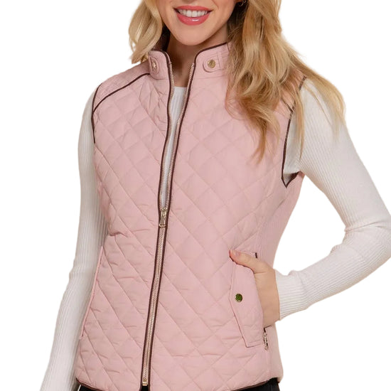 Woman wearing a pink quilted vest on a white background equestrian fashion outfitters