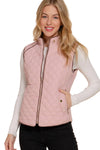 Woman wearing a pink quilted vest on a white background equestrian fashion outfitters
