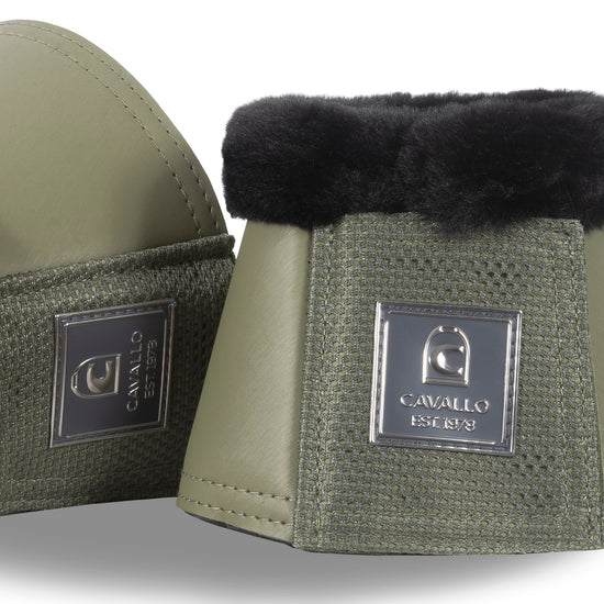 Green equestrian bell boots with black fur lining on a white background