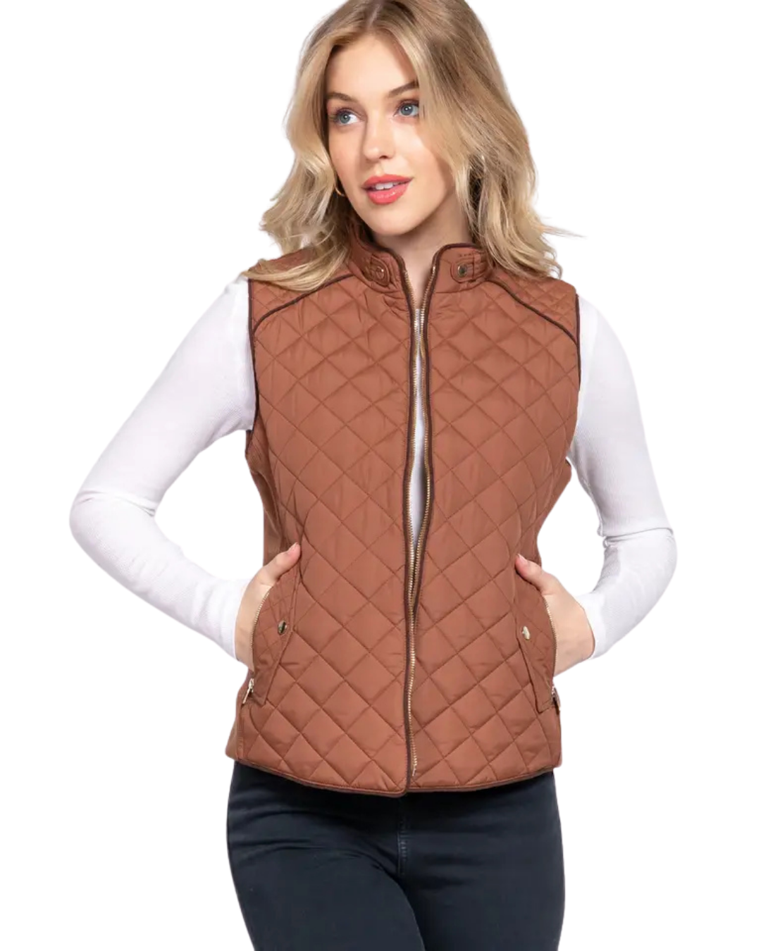 A woman modeling a brown diamond-quilted zip-up vest over a white long-sleeve top and dark pants, photographed against a plain white background. equestrian fashion outfitters