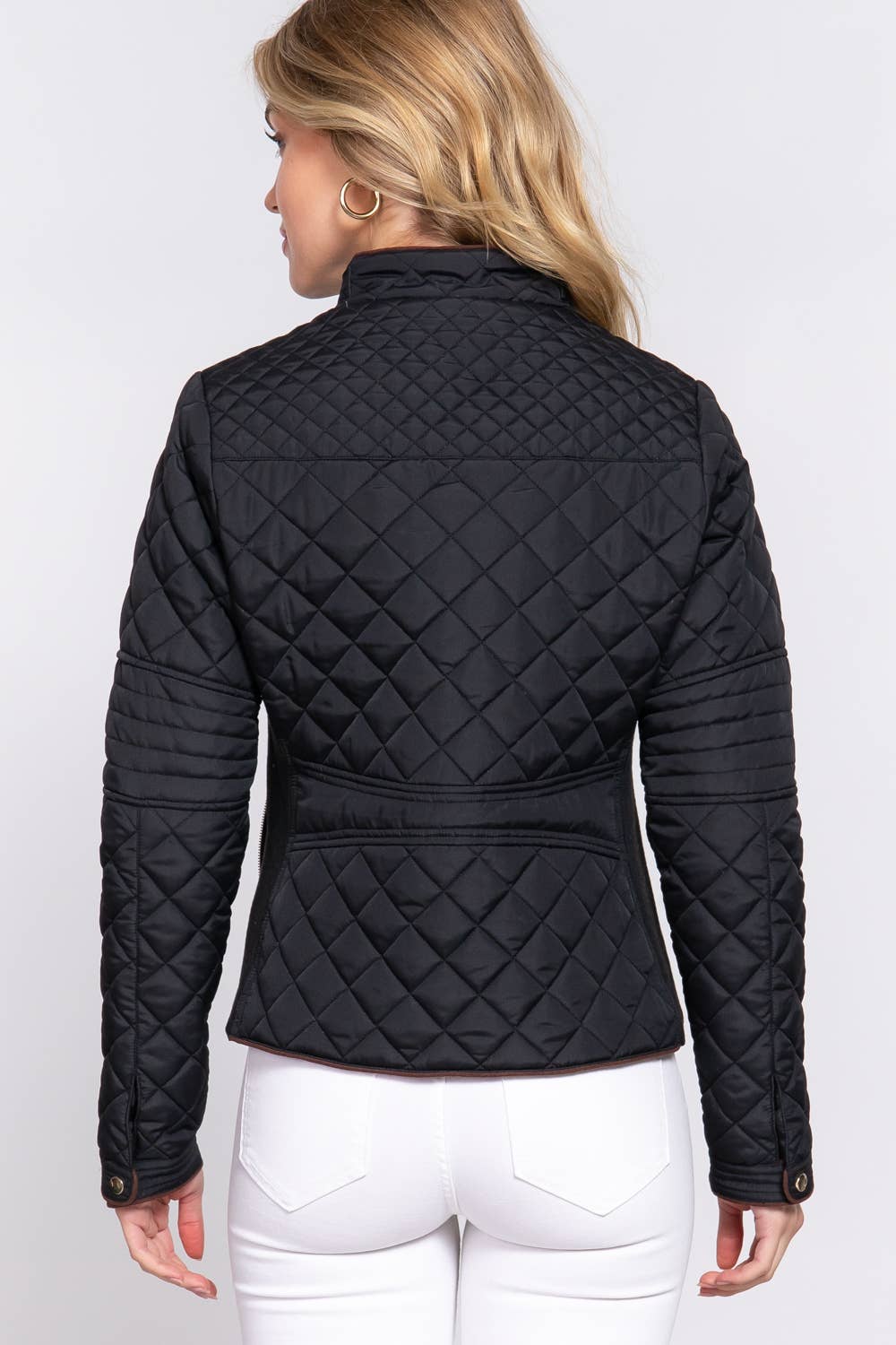 Person wearing a black quilted jacket on a white background equestrian fashion outfitters