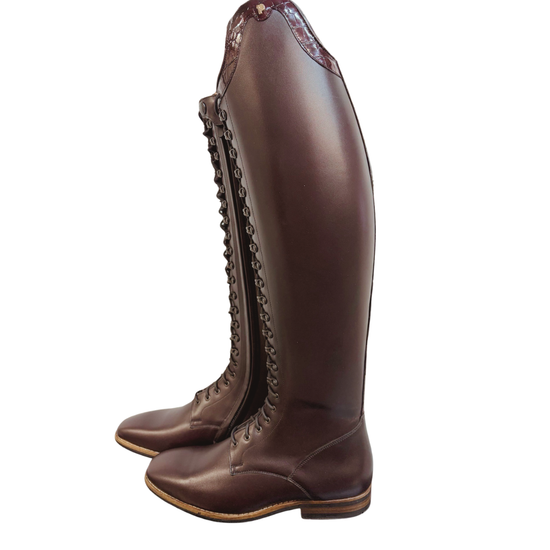 A pair of dark brown  oxblood leather tall riding boots with lace-up front and a side zipper, shown from a side profile view on a white background.equestrian fashion outfitters