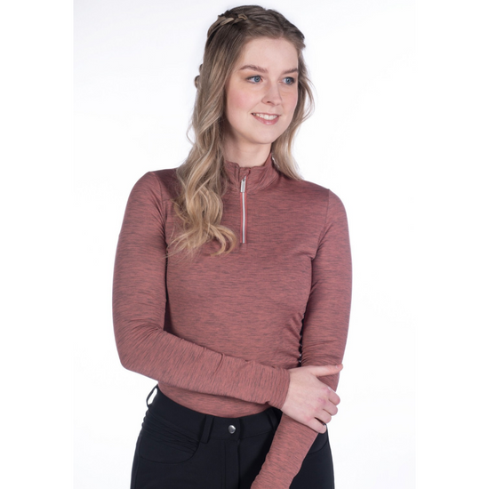 girl with blond hair wearing a pink rust coloured heathered shirt with a 1/4 quarter zip with long sleeves and black breeches on a white background equestrian fashion outfitters