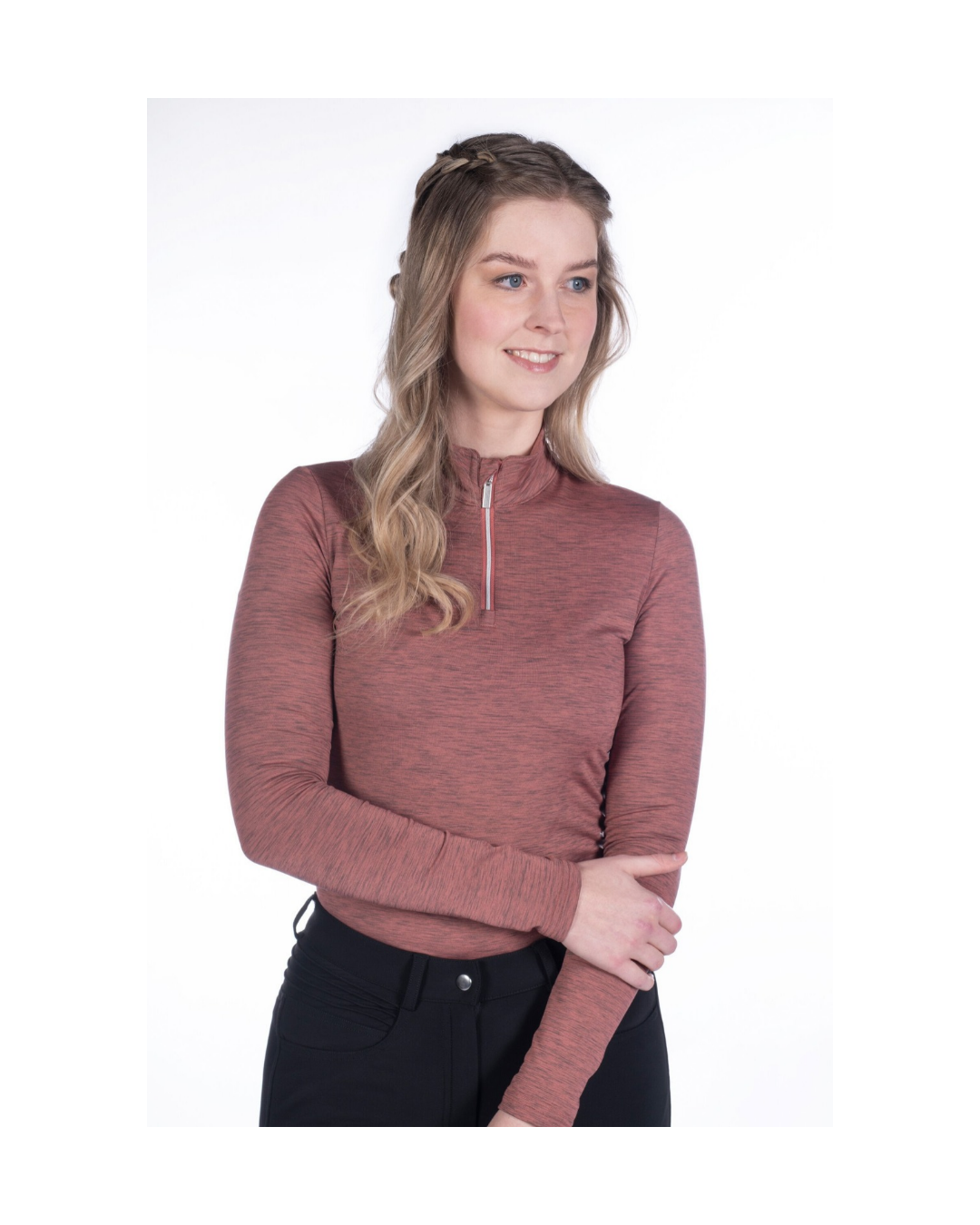 girl with blond hair wearing a pink rust coloured heathered shirt with a 1/4 quarter zip with long sleeves and black breeches on a white background equestrian fashion outfitters