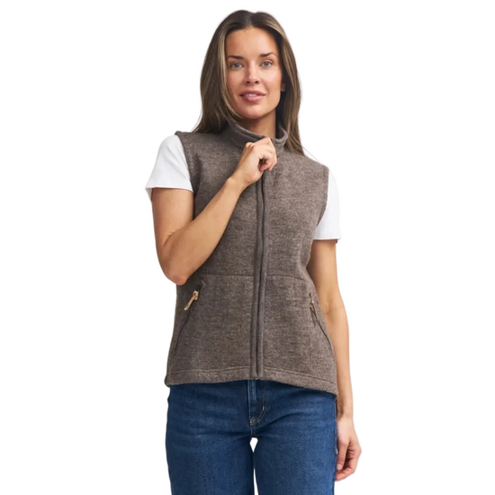 woman wearing brown wool vest with zipper and side zip pockets wearing a white t shirt and jeans equestrian fashion outfitters