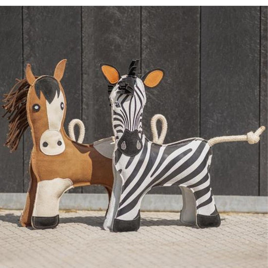 Stuffed horse and zebra toys against a dark wooden panel background equestrian fashion outfitters