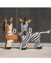 Stuffed horse and zebra toys against a dark wooden panel background equestrian fashion outfitters