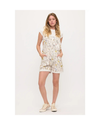 A woman modeling overalls or shortalls with roosters and chickens and flowers on a white background with sneakers equestrian fashion outfitters