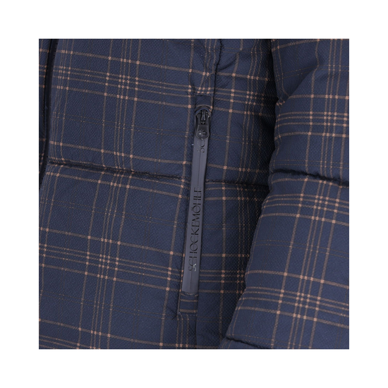 Close-up of a navy blue puffer jacket with a tan and white plaid pattern and a black zipper featuring the brand name Schockemohle equestrian fashion outfitters