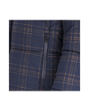 Close-up of a navy blue puffer jacket with a tan and white plaid pattern and a black zipper featuring the brand name Schockemohle equestrian fashion outfitters