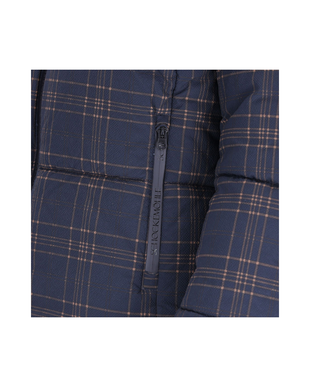 Close-up of a navy blue puffer jacket with a tan and white plaid pattern and a black zipper featuring the brand name Schockemohle equestrian fashion outfitters