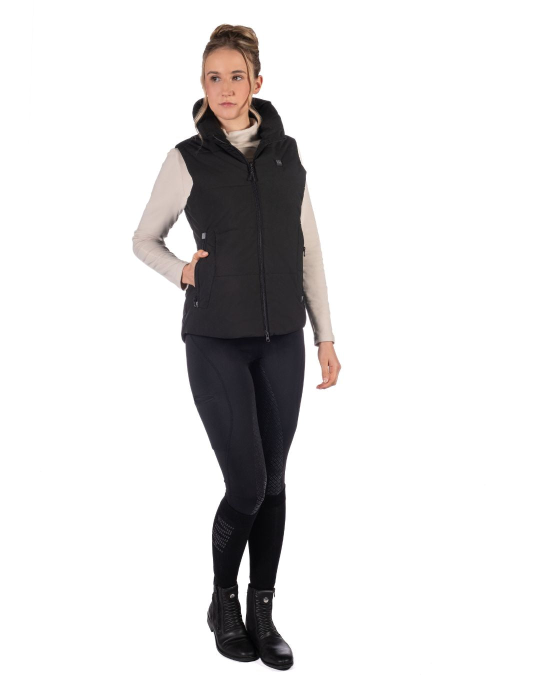 Woman wearing a Black HKM Canada Heated Vest and a light gray long-sleeve shirt on a white background
