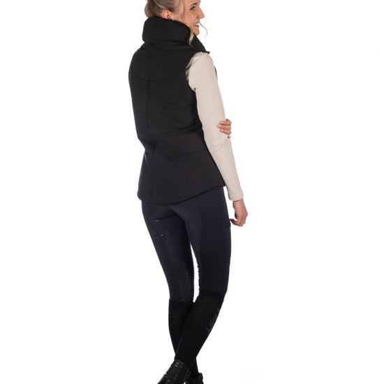 Woman wearing a Black HKM Canada Heated Vest and a light gray long-sleeve shirt on a white background