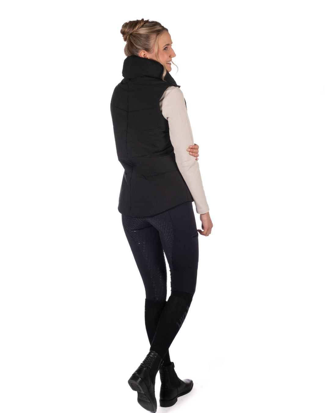 Woman wearing a Black HKM Canada Heated Vest and a light gray long-sleeve shirt on a white background