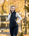 Woman wearing a Black HKM Canada Heated Vest and a light gray long-sleeve shirt on a white background