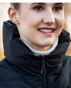 Close-up of a woman wearing a black  HKM vest with a blurred background