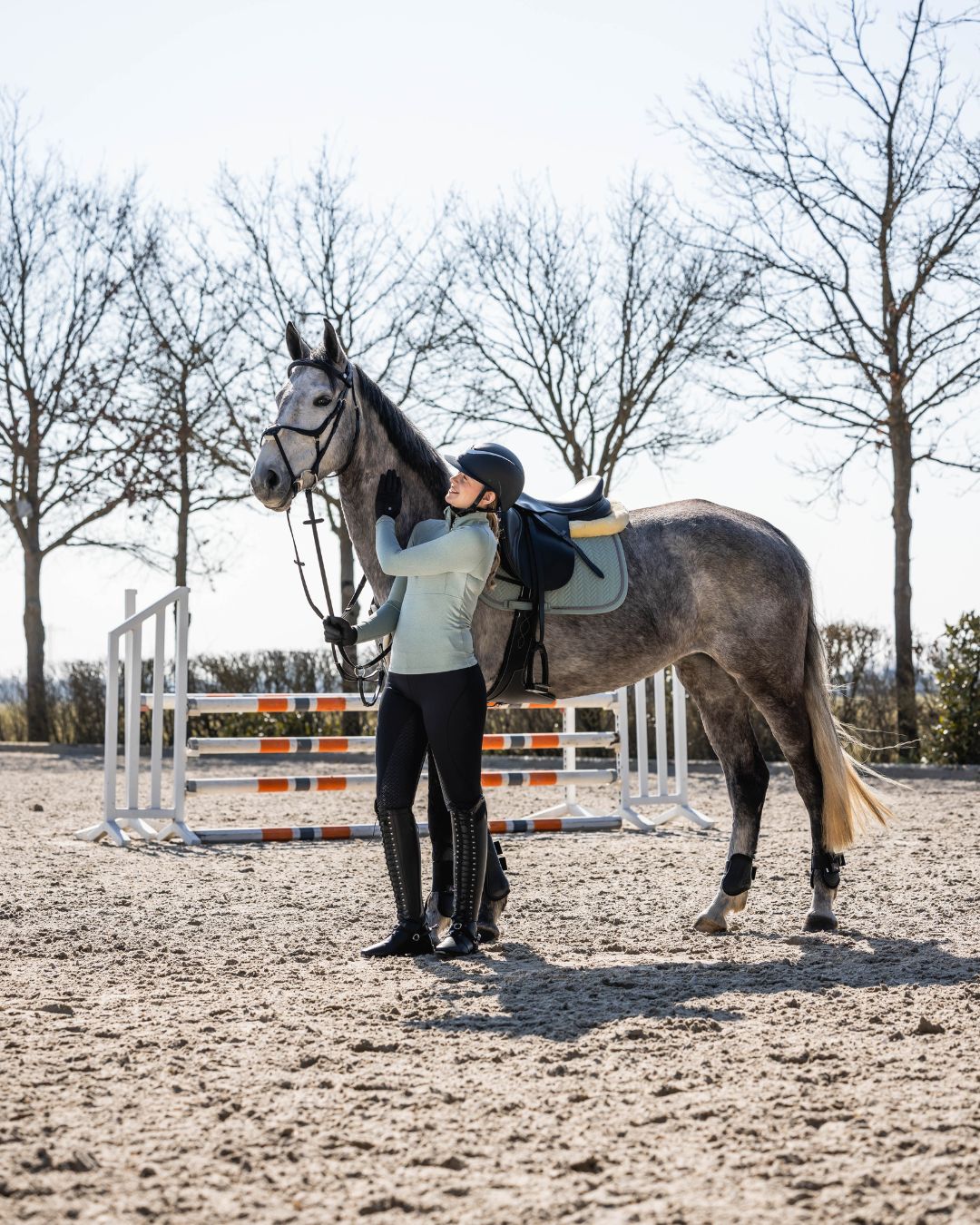 Person wearing HKM Supersoft II Functional 1/4 Zip Shirt in sage next to a horse