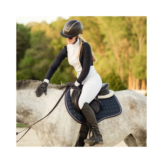 Person riding a horse with a blue equinavia saddle pad