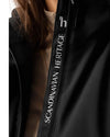 Close-up of a black jacket with 'Scandinavian Heritage' branding on a white background