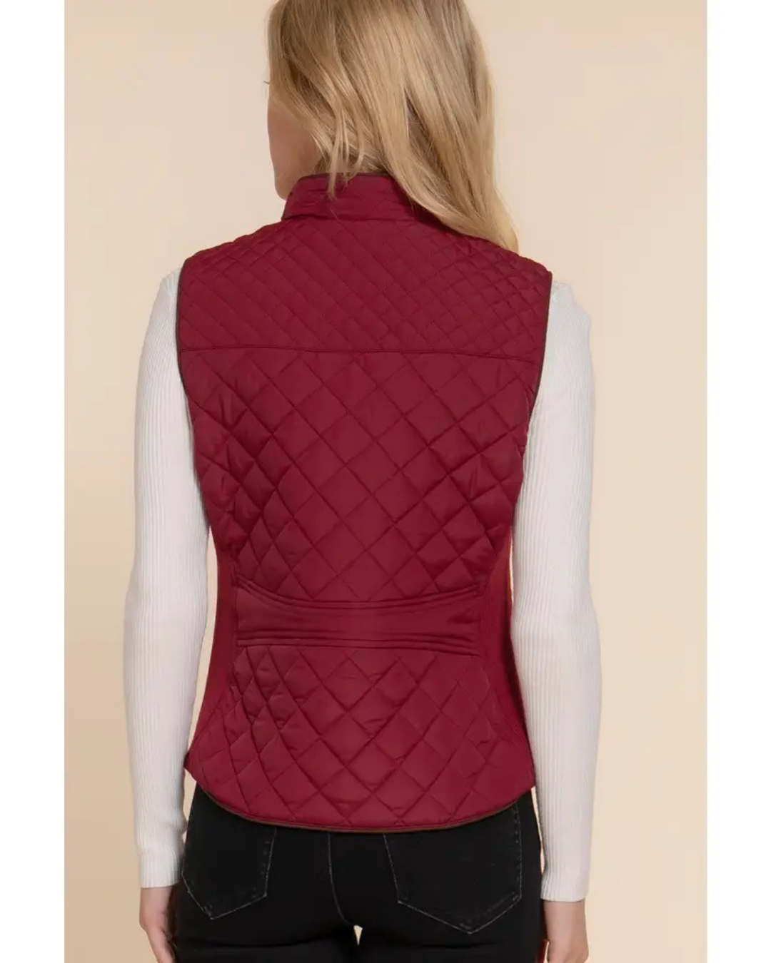 Red quilted vest worn by a person on a beige background equestrian fashion outfitters