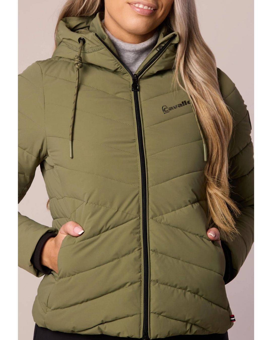 Green puffer jacket with brand logo on a neutral background