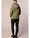 Person wearing a green puffer jacket and black leggings on a beige background