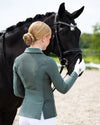 Woman in equestrian attire standing next to a horse in an outdoor setting equestrian fashion outfitters