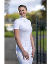 Woman wearing a white equestrian outfit with a blurred outdoor background Equestrian fashion outfitters