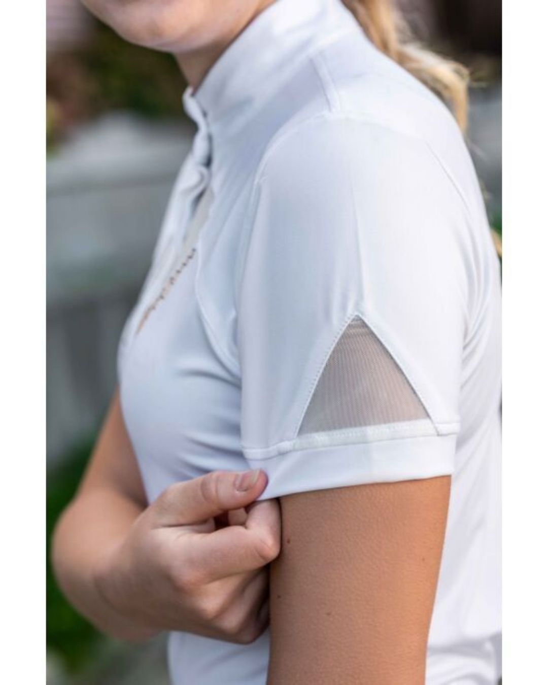 White shirt with sheer sleeves worn by a person, blurred background Equestrian fashion outfitters