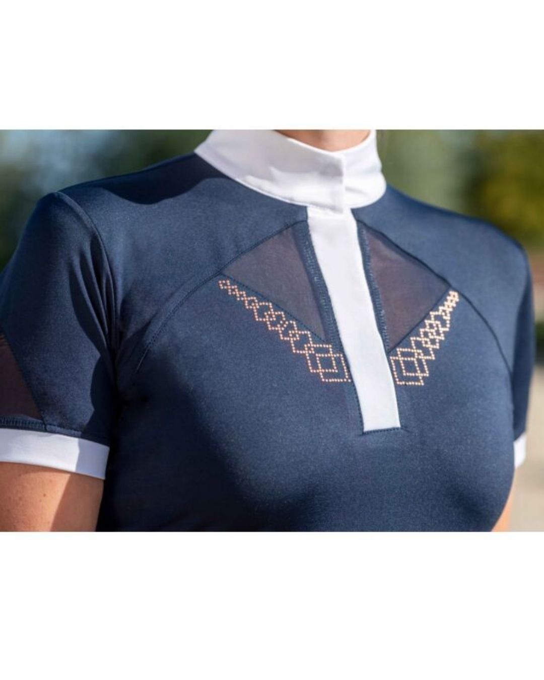 Navy blue top with white collar and geometric embroidery on a blurred outdoor background Equestrian fashion outfitters