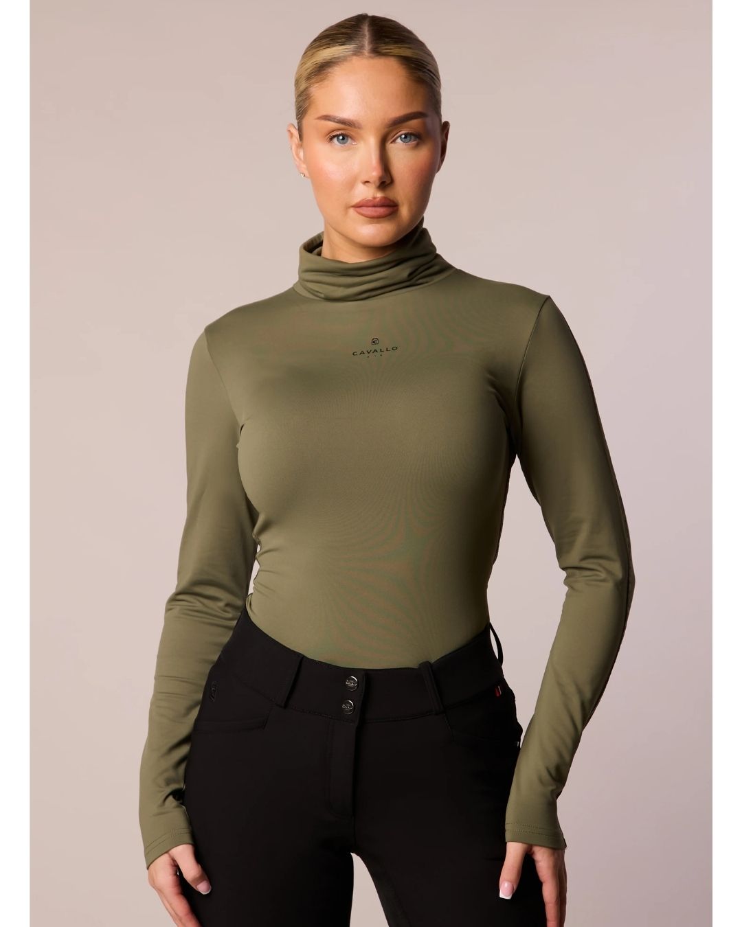 Woman wearing an olive green long-sleeve top with a brand logo cavallo on a beige background