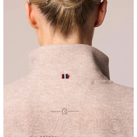Back view of a person wearing a beige equestrian jacket with a brand logo on a plain background