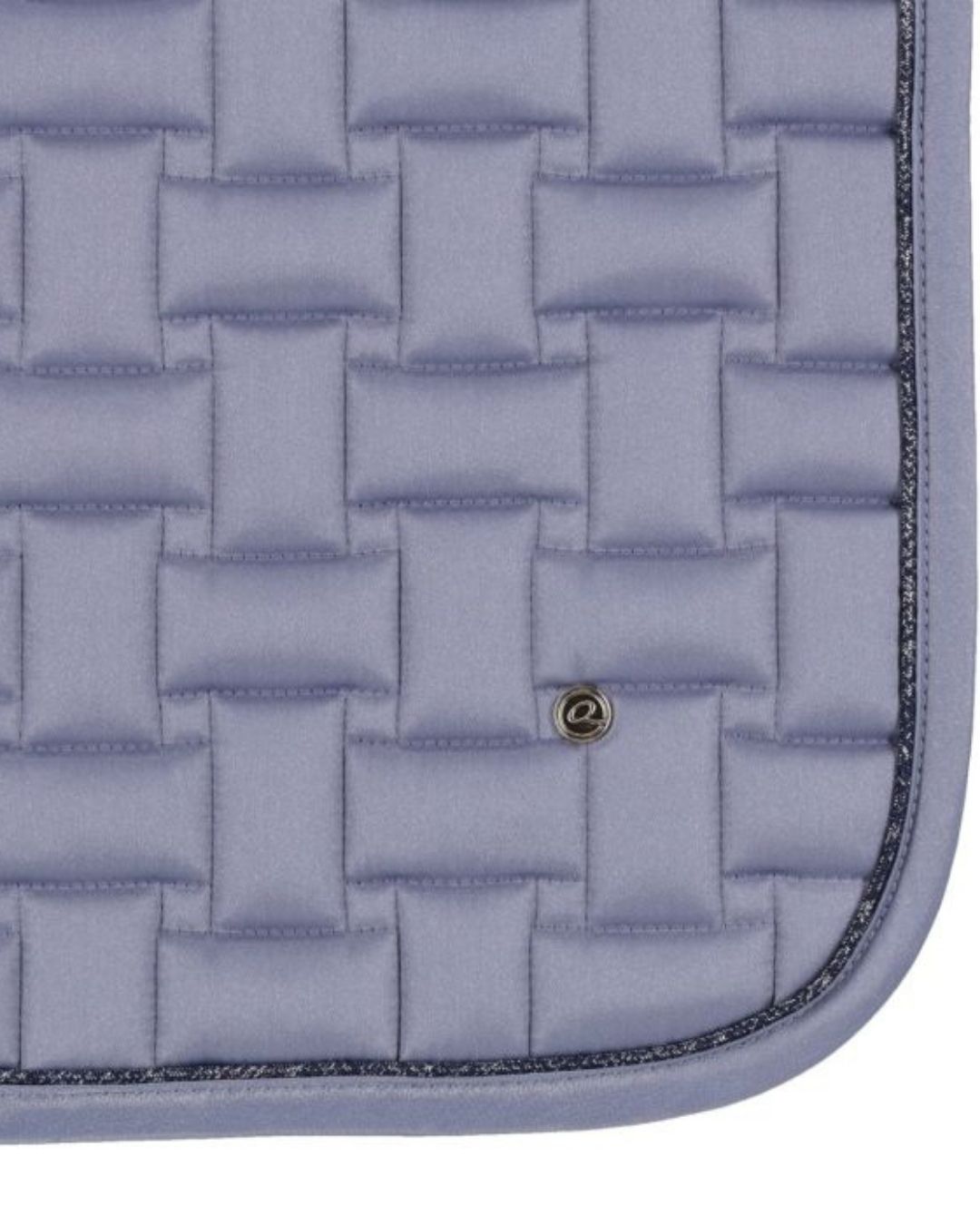 Close-up of a quilted blue saddle pad with a woven pattern.