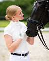 Woman in equestrian qhp show shirt short sleeve petting a black horse in an outdoor setting equestrian fashion outfitters