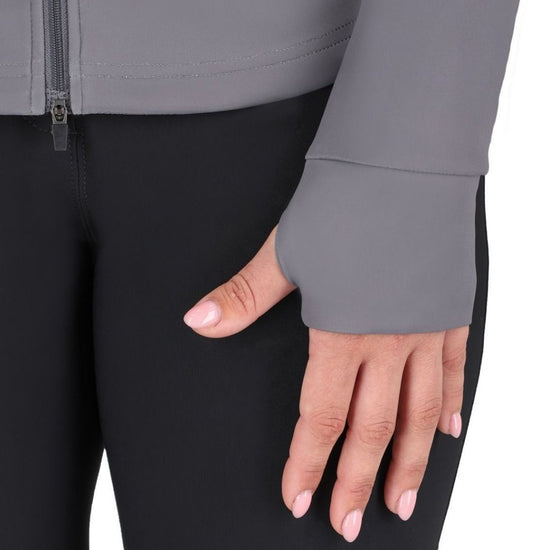 Close-up of a hand wearing a gray sleeve with a black pant background equestrian fashion outfitters