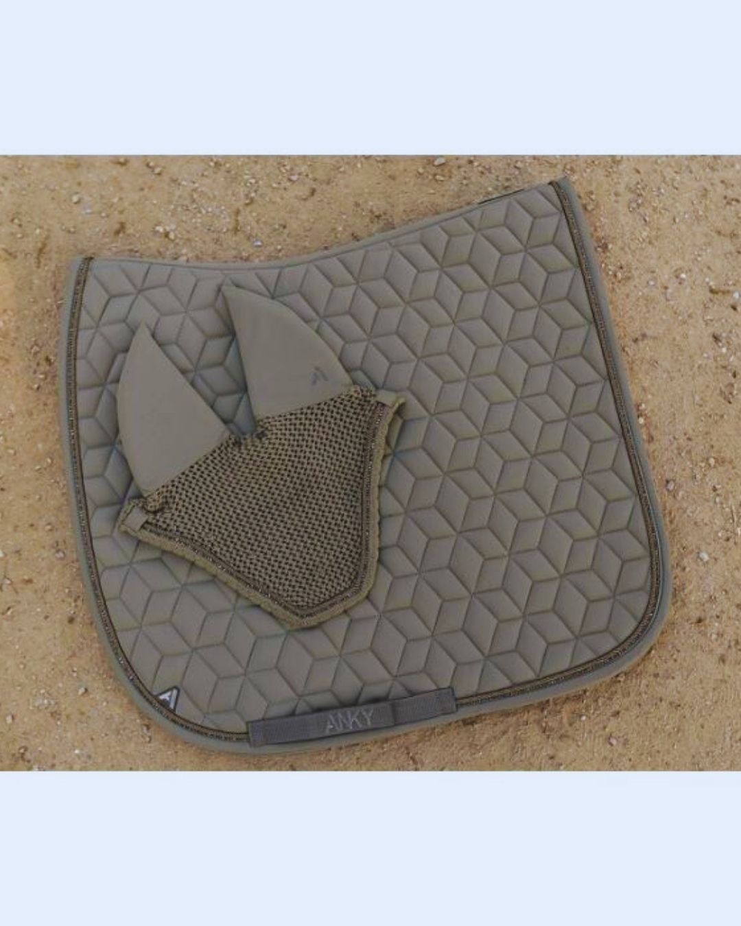 Quilted saddle pad with a ear bonnet on a beige  khaki background
