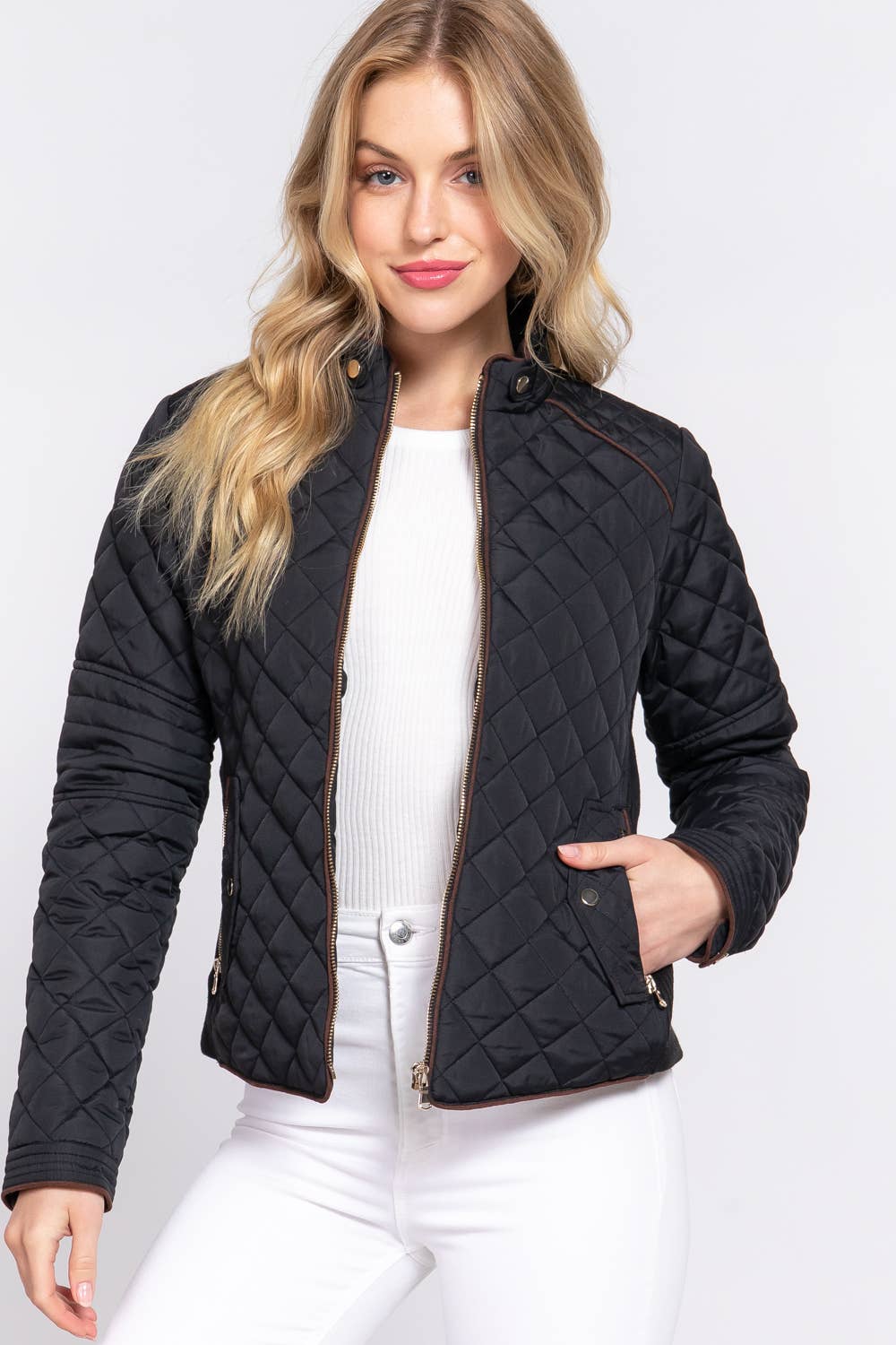 Woman wearing a black quilted jacket on a white background equestrian fashion outfitters
