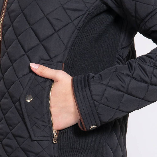 Black quilted jacket with a hand in the pocket on a white background equestrian fashion outfitters
