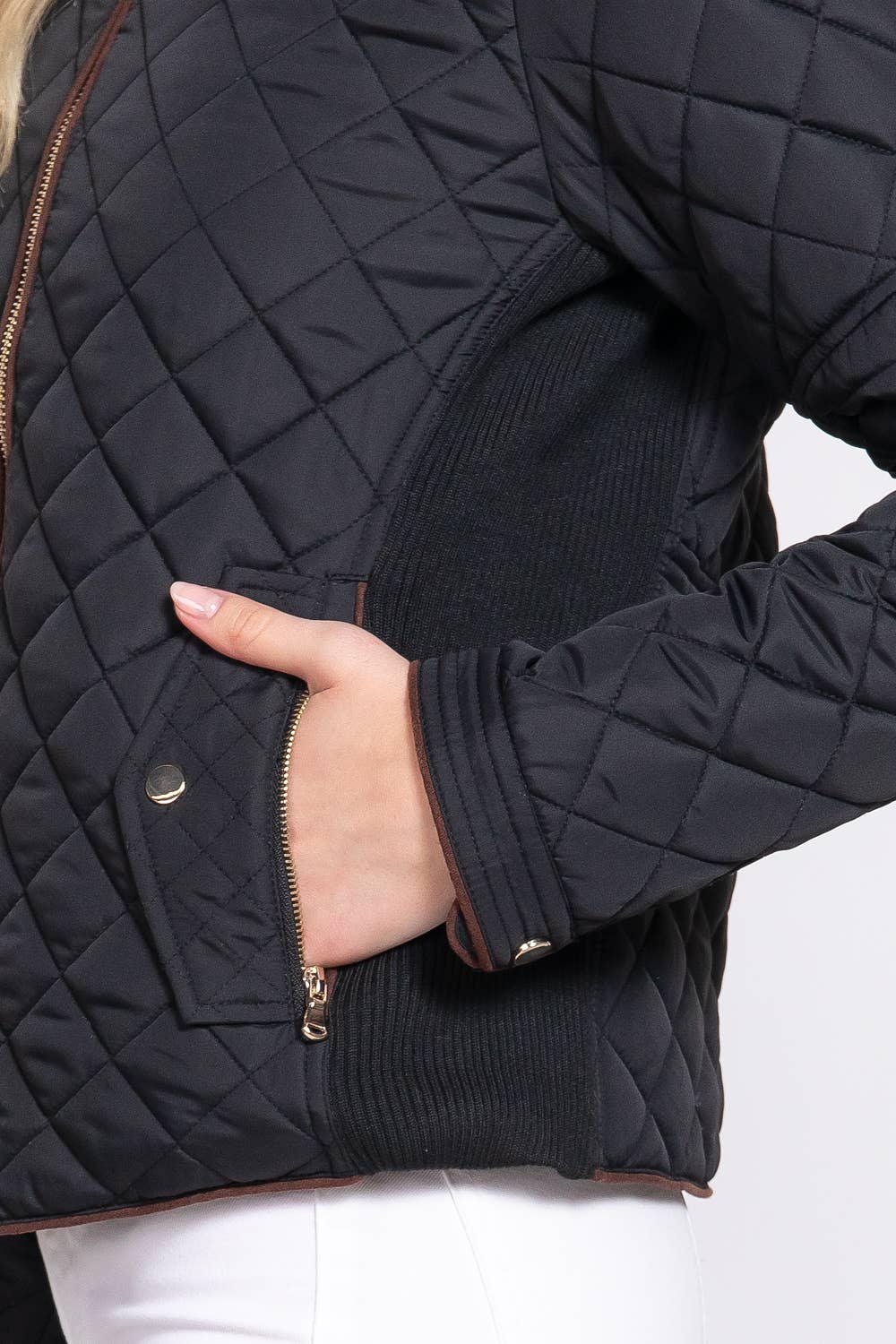 Black quilted jacket with a hand in the pocket on a white background equestrian fashion outfitters