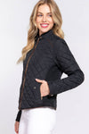 Woman wearing a black quilted jacket on a white background equestrian fashion outfitters