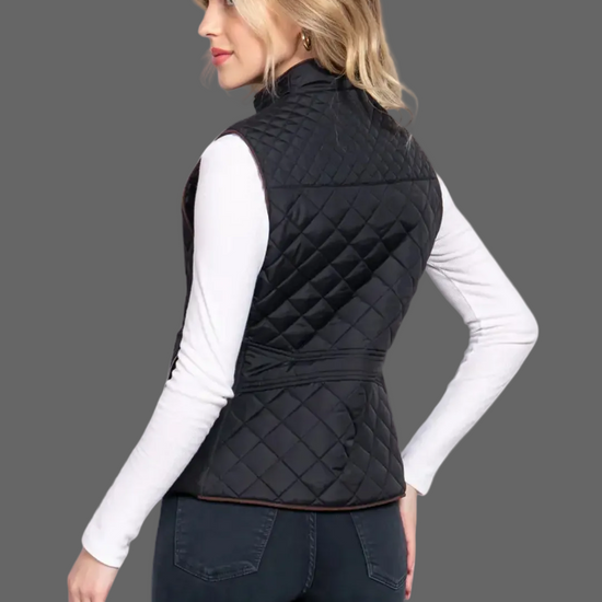 Woman wearing a black quilted vest on a white background equestrian fashion outitters