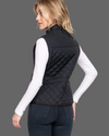 Woman wearing a black quilted vest on a white background equestrian fashion outitters