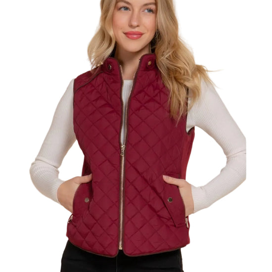 Woman wearing a red burgundy quilted vest against a white background equestrian fashion outfitters
