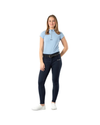 A woman modeling a light blue short-sleeve polo shirt with a half-zip neckline, paired with dark navy equestrian riding breeches and white sneakers, set against a plain white background. equestrian fashion outfitters