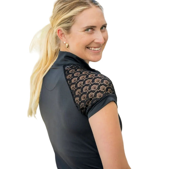 Woman wearing a black shirt with lace detailing outdoors kastel equestrian fashion outfitters