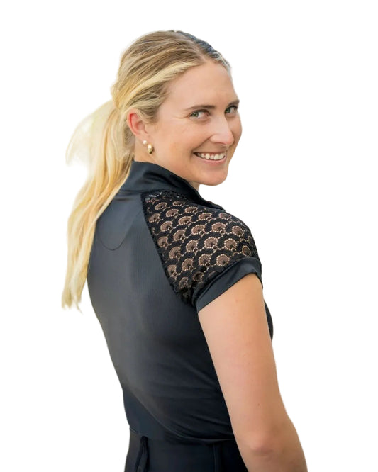 Woman wearing a black shirt with lace detailing outdoors kastel equestrian fashion outfitters