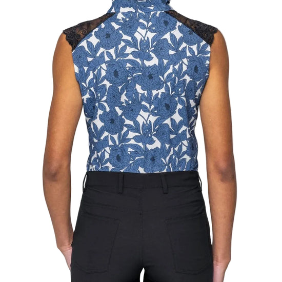 Person wearing a blue floral sleeveless top with black lace details on a white background Kastel equestrian fashion outfitters