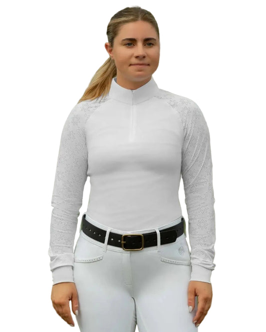 Woman wearing a white long-sleeve show shirt top and white pants with a black belt, standing outdoors. equestrian fashion outfitters
